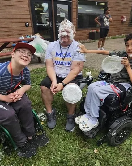 Jason volunteering at an MDA Walk, taking a pie in the face from a young participant